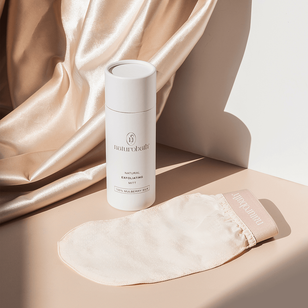 Exfoliating silk glove on soft silk fabric background